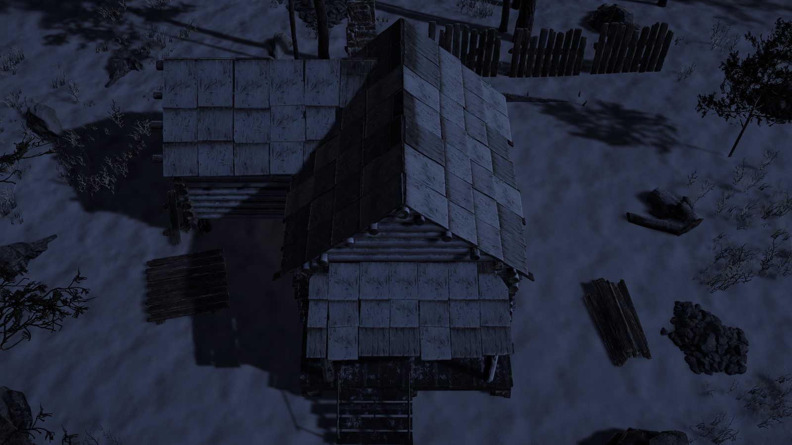 The log cabin from above at night in blue moonlight, its roof and porch dark, with nothing showing that a fire burns inside.